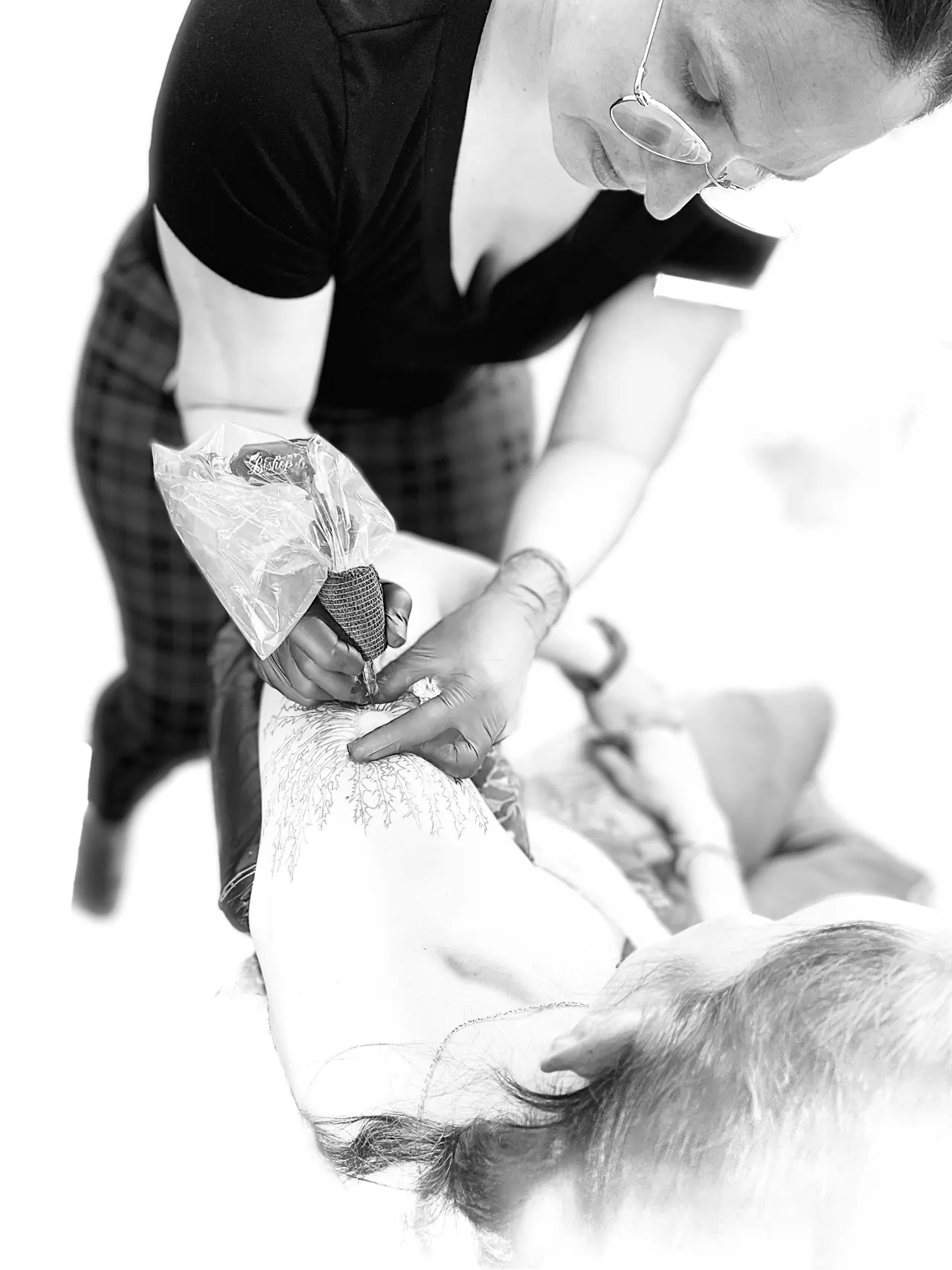 Sabrina, tatoueuse chez Loquis Tattoo, en train de tatouer une cliente